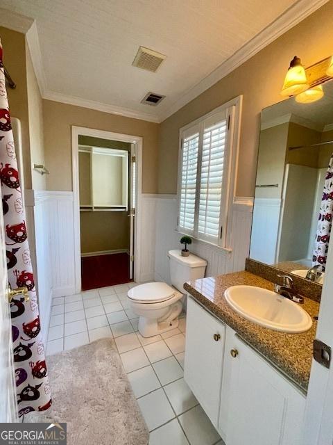 bathroom featuring tile patterned flooring, vanity, toilet, and ornamental molding