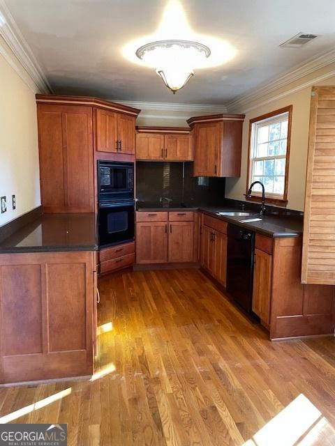 kitchen featuring sink, tasteful backsplash, light hardwood / wood-style flooring, black appliances, and ornamental molding