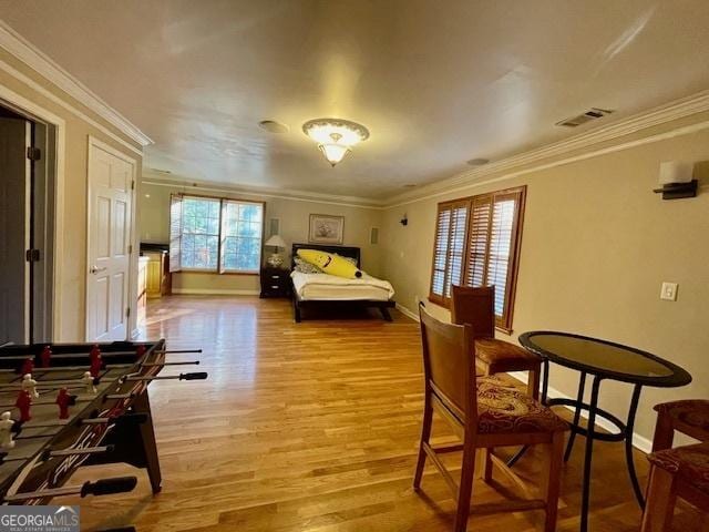 bedroom featuring light wood-type flooring and crown molding