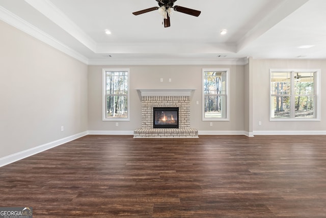 unfurnished living room with a fireplace, plenty of natural light, and dark hardwood / wood-style floors