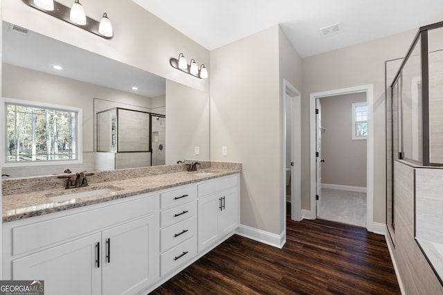 bathroom with vanity, hardwood / wood-style flooring, toilet, and an enclosed shower