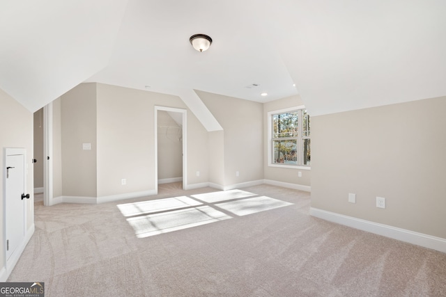 bonus room featuring light carpet and vaulted ceiling