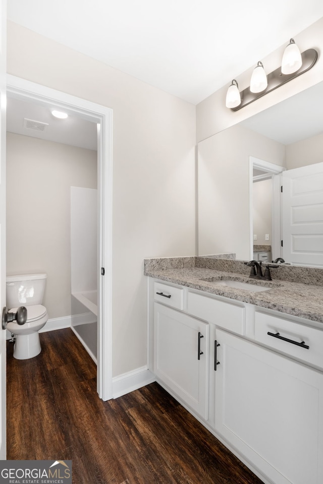 bathroom featuring hardwood / wood-style floors, vanity, and toilet