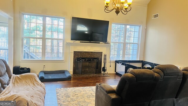 living room featuring plenty of natural light, wood-type flooring, and a chandelier