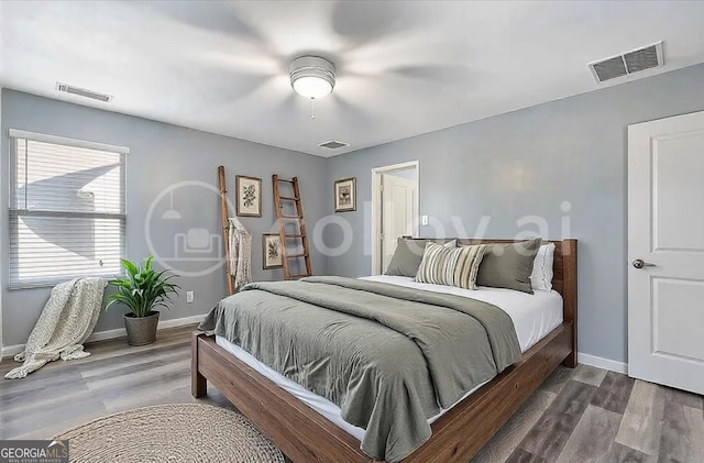 bedroom featuring visible vents, baseboards, and wood finished floors