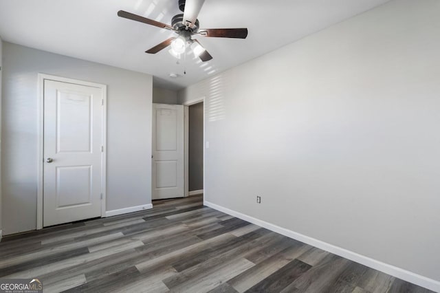 unfurnished bedroom featuring ceiling fan, baseboards, and dark wood finished floors