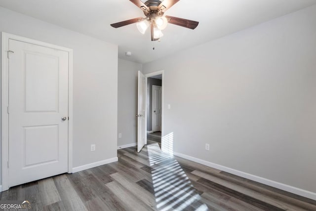 bedroom featuring ceiling fan, baseboards, and wood finished floors