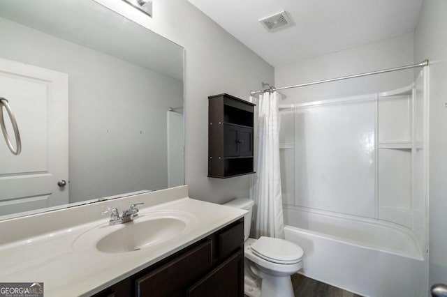 bathroom with toilet, wood finished floors, vanity, visible vents, and shower / bathtub combination with curtain