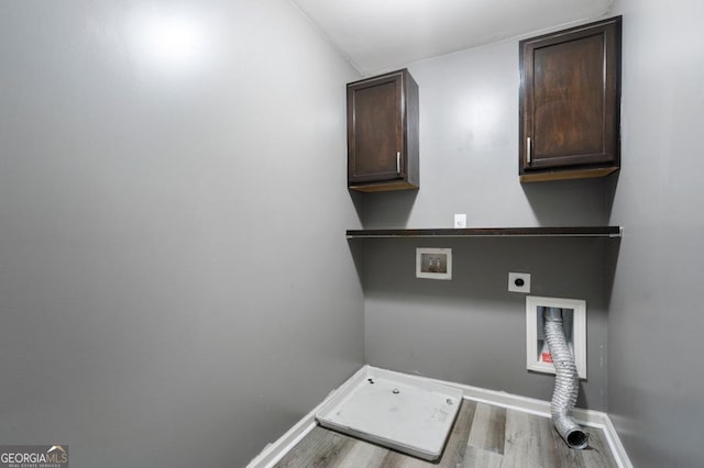 laundry room featuring light wood finished floors, hookup for a washing machine, cabinet space, electric dryer hookup, and baseboards