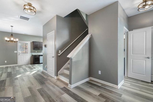 staircase with visible vents, baseboards, and wood finished floors