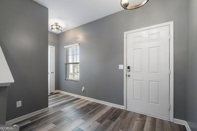 entryway featuring dark wood-type flooring and baseboards