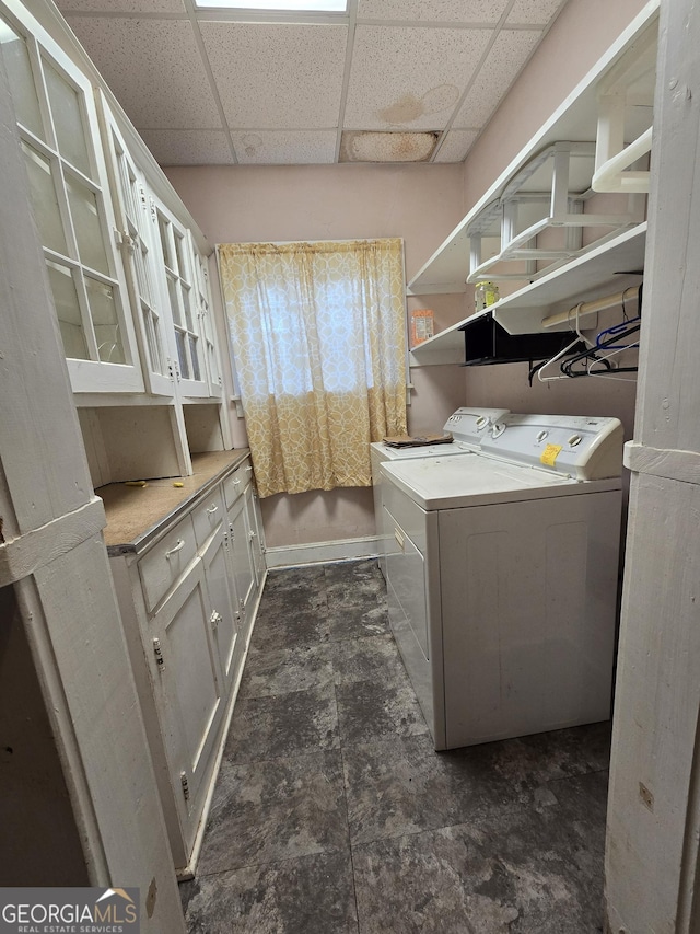 laundry room featuring washer and clothes dryer and cabinets