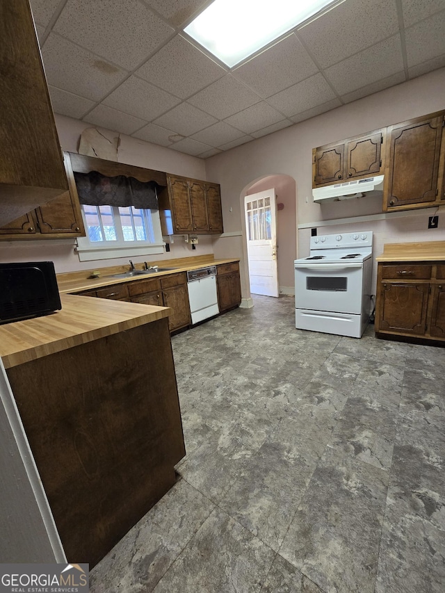 kitchen featuring sink, wooden counters, white appliances, and a drop ceiling