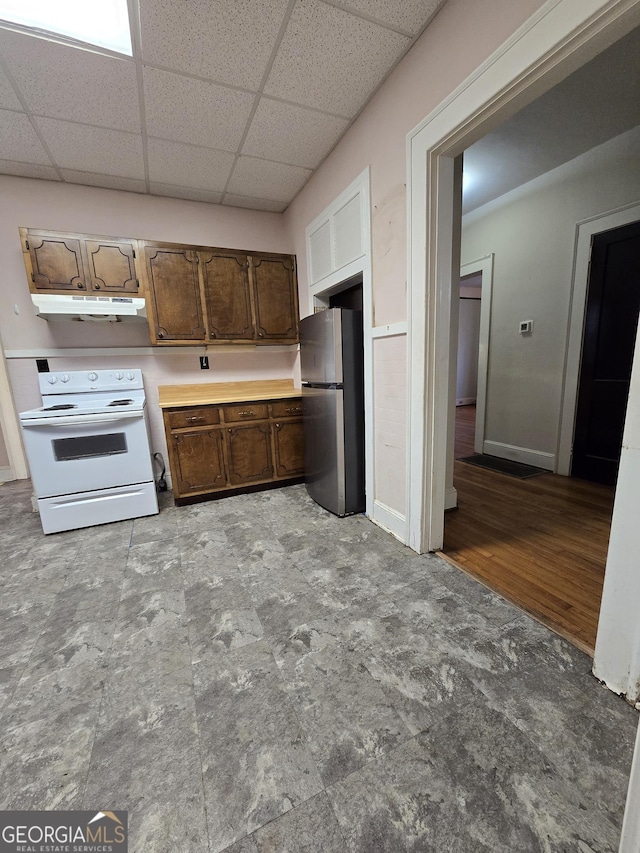 kitchen with a paneled ceiling, white electric stove, and stainless steel refrigerator