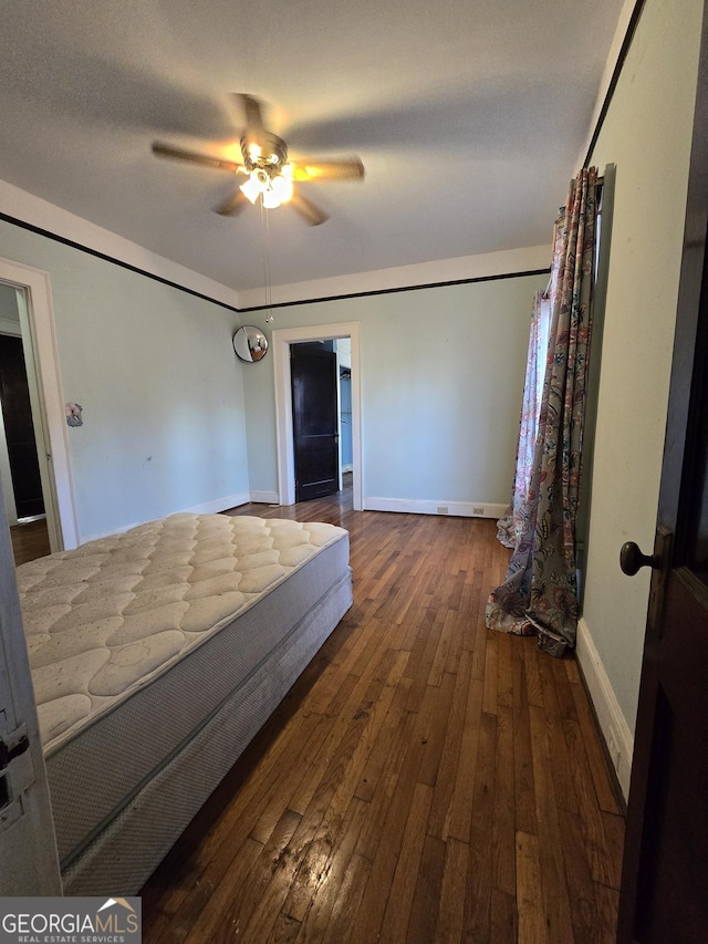 bedroom with ceiling fan and dark wood-type flooring