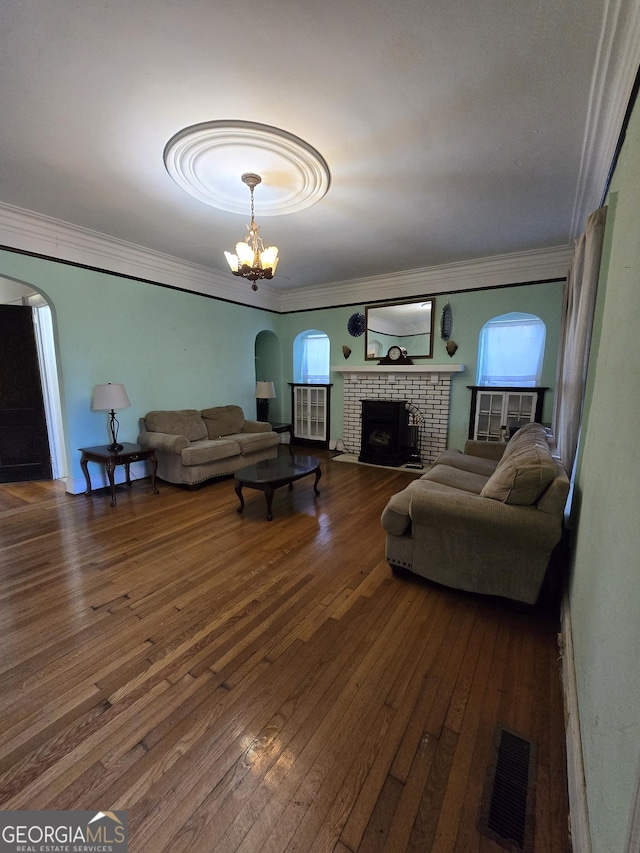 living room with a chandelier, dark hardwood / wood-style floors, and ornamental molding