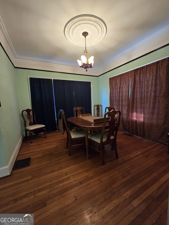 dining room featuring a chandelier, ornamental molding, and dark wood-type flooring