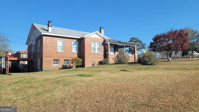 view of side of home with a deck and a yard