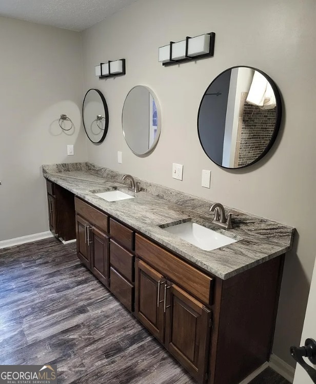 bathroom featuring hardwood / wood-style floors, vanity, and a textured ceiling