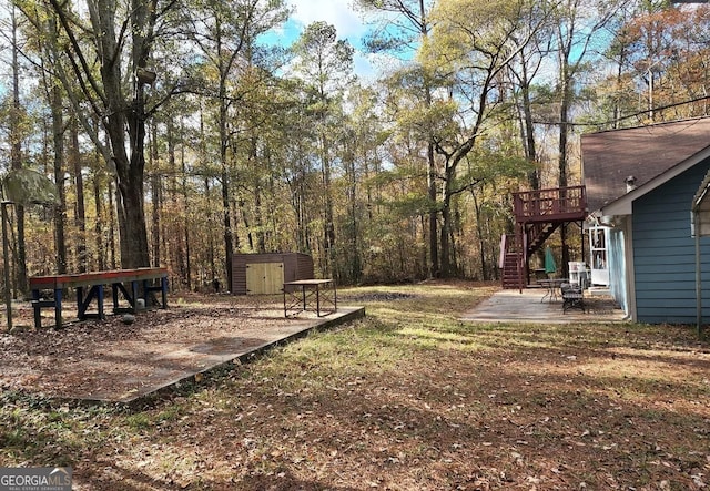 view of yard with a storage shed, a patio, and a wooden deck