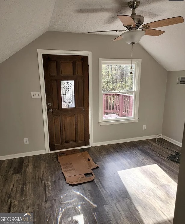 foyer with a textured ceiling, lofted ceiling, ceiling fan, and dark wood-type flooring