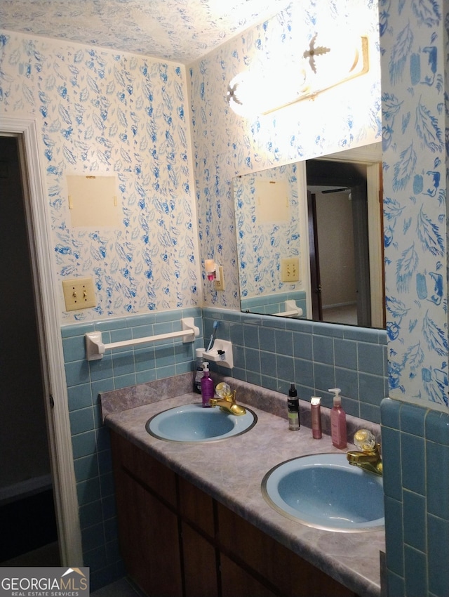 bathroom featuring vanity and tile walls