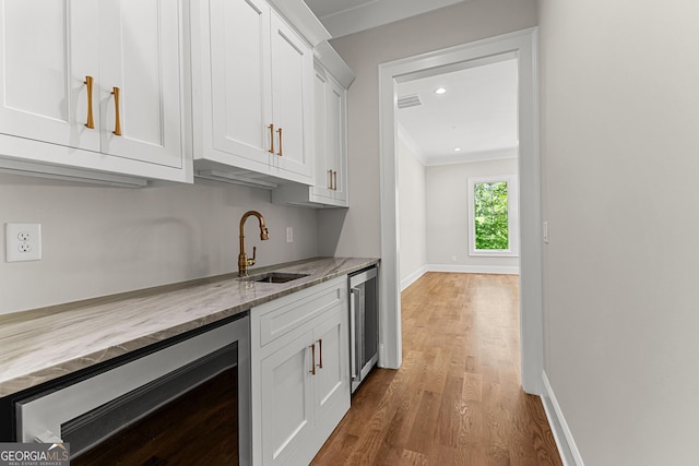bar with beverage cooler, visible vents, ornamental molding, and a sink