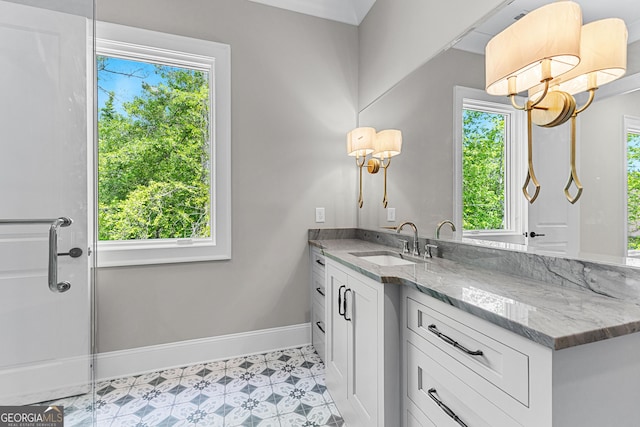 bathroom with baseboards, a notable chandelier, and vanity