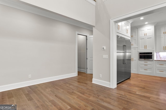 unfurnished living room featuring recessed lighting, baseboards, and wood finished floors