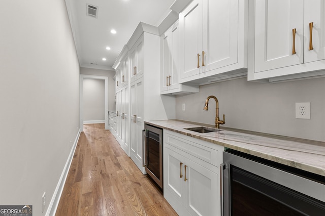 kitchen with recessed lighting, white cabinetry, a sink, and wine cooler