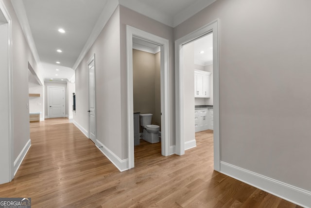 hall with crown molding, recessed lighting, baseboards, and light wood finished floors