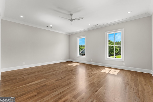 unfurnished room with crown molding, visible vents, wood finished floors, baseboards, and ceiling fan
