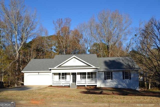 view of front of property featuring a porch, a garage, and a front yard