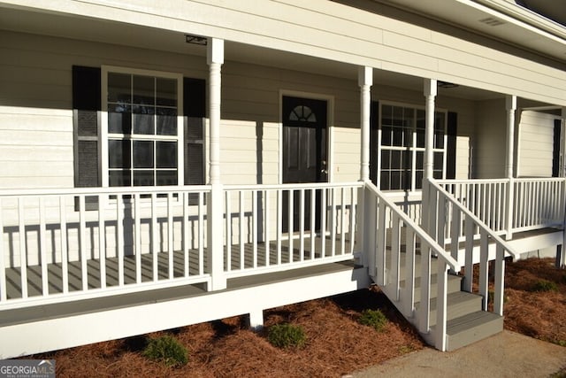 view of exterior entry featuring covered porch