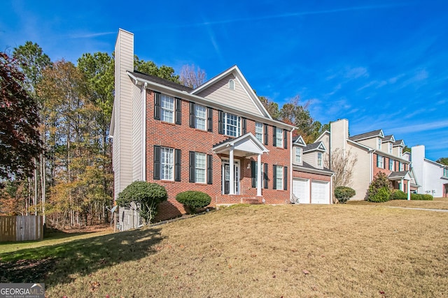 colonial inspired home with a garage and a front lawn