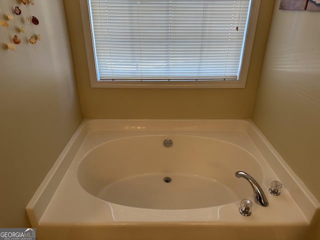 bathroom with a tub to relax in and a wealth of natural light