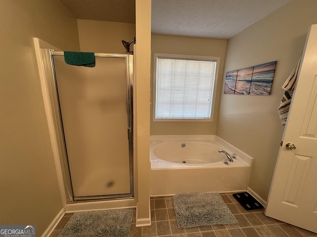 bathroom featuring tile patterned flooring, independent shower and bath, and a textured ceiling