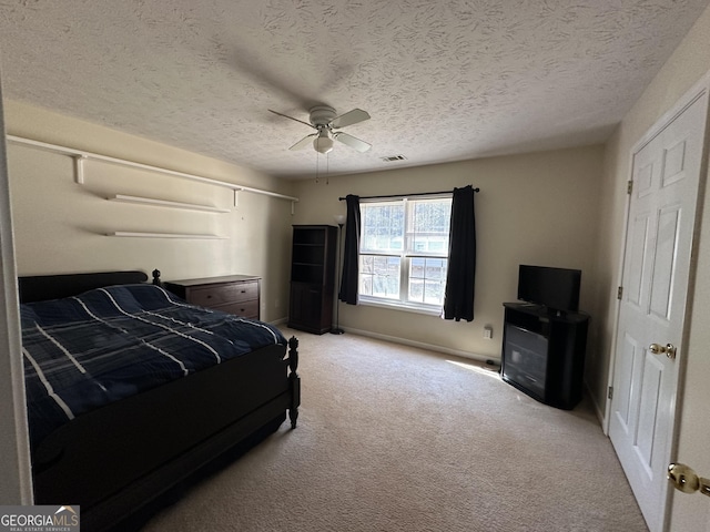 carpeted bedroom featuring ceiling fan and a textured ceiling