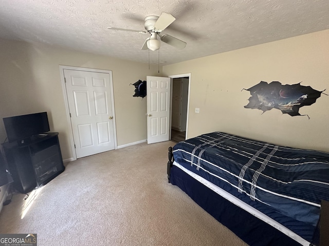 bedroom with ceiling fan, light carpet, and a textured ceiling