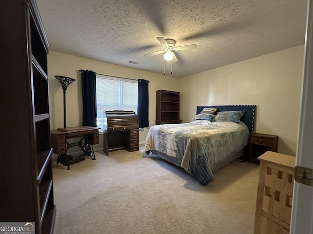 carpeted bedroom with ceiling fan and a textured ceiling