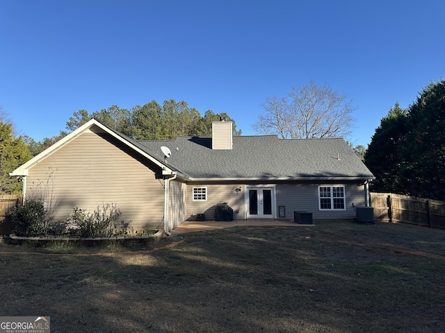 back of house with french doors, a yard, and central AC