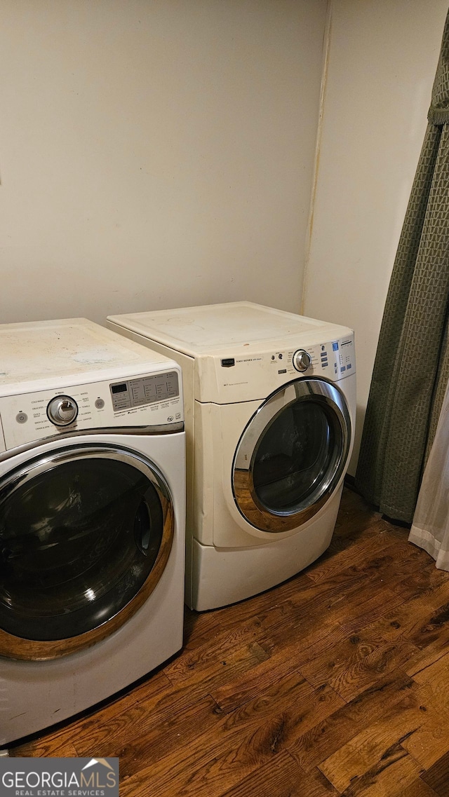 laundry area featuring dark wood-type flooring and washing machine and clothes dryer