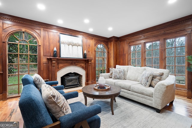 living room with wooden walls, plenty of natural light, and light hardwood / wood-style floors