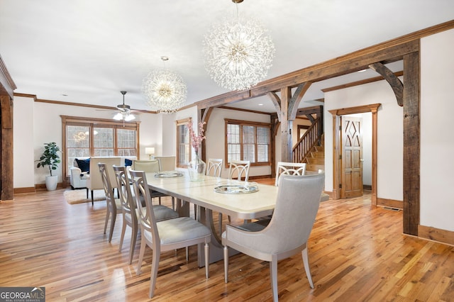 dining area with ceiling fan with notable chandelier, light hardwood / wood-style floors, and crown molding