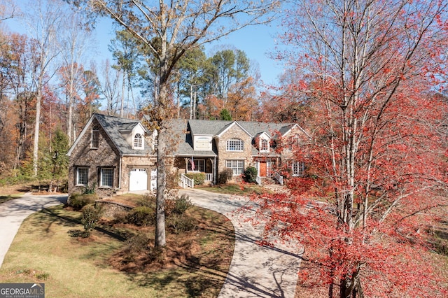 view of front of house featuring driveway, a garage, and a front yard