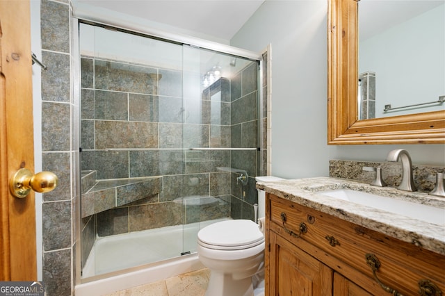 bathroom with tile patterned flooring, vanity, toilet, and a shower with shower door