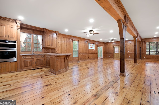 kitchen featuring plenty of natural light, light hardwood / wood-style floors, ornamental molding, and decorative columns