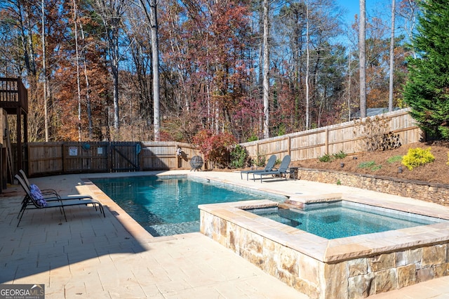 view of swimming pool featuring a patio area and an in ground hot tub