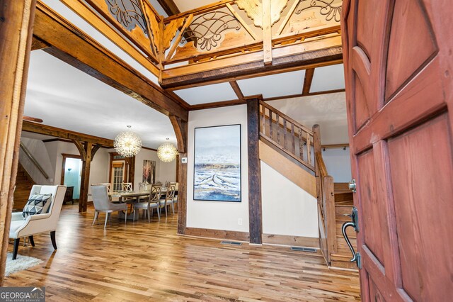 entryway featuring crown molding, a chandelier, and light wood-type flooring