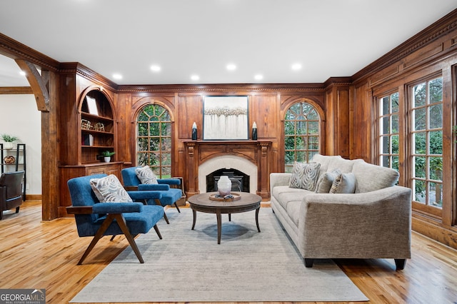 living room featuring crown molding and light hardwood / wood-style flooring